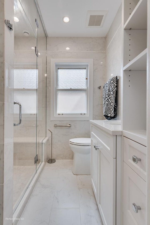 5448 N Lieb Ave, Chicago, IL 60630 - bathroom featuring a shower stall, toilet, marble finish flooring, vanity, and tile walls