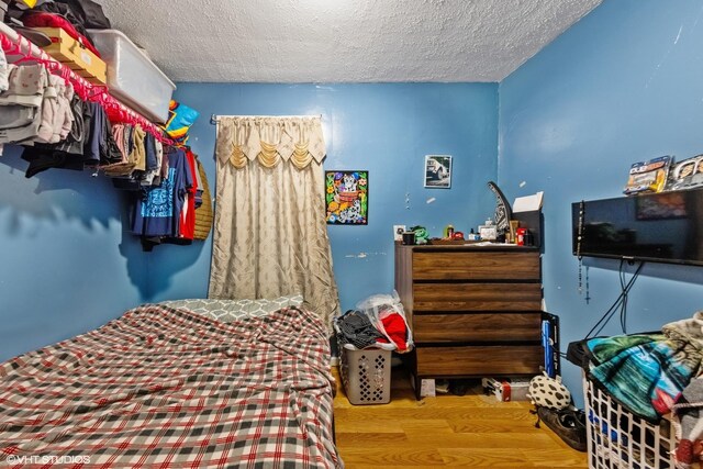 2625 S Drake Ave, Chicago, IL 60623 - bedroom featuring a textured ceiling and wood finished floors