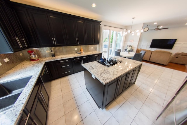 1034 Idaho St, Carol Stream, IL 60188 - kitchen with gas cooktop, a center island, light stone countertops, light tile patterned floors, and decorative backsplash