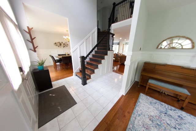 1034 Idaho St, Carol Stream, IL 60188 - foyer featuring a decorative wall, stairway, a chandelier, wainscoting, and wood finished floors