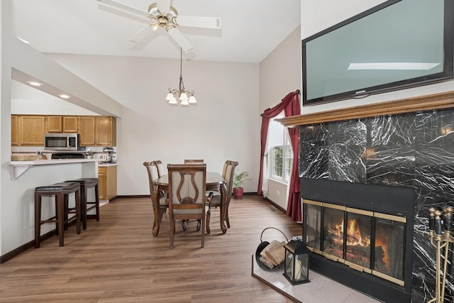 19927 S Edinburgh Ln Unit 0, Frankfort, IL 60423 - dining room featuring wood finished floors, a chandelier, a ceiling fan, and a fireplace