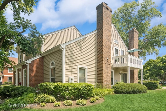 54 S Stonington Dr Unit 92, Palatine, IL 60074 - view of side of property featuring a balcony, a chimney, a lawn, and brick siding