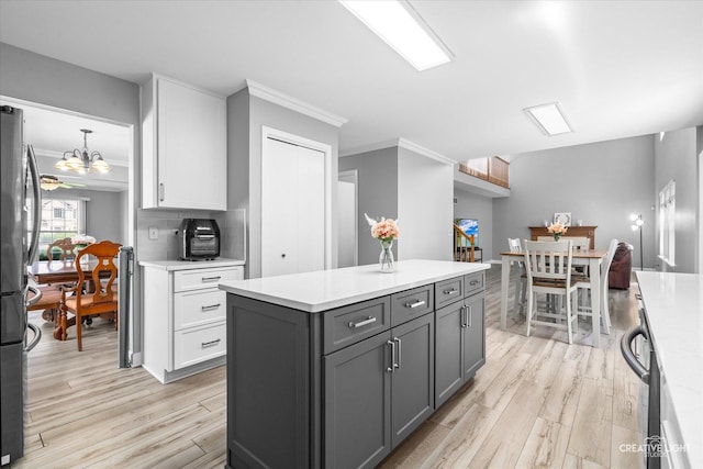 1889 Shore Line Ct, Romeoville, IL 60446 - kitchen featuring appliances with stainless steel finishes, light wood-type flooring, ornamental molding, light countertops, and white cabinetry