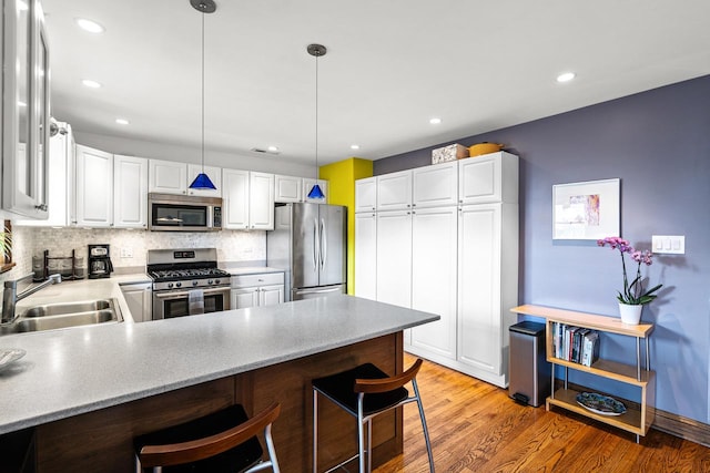 4413 N Malden St Unit 2S, Chicago, IL 60640 - kitchen featuring appliances with stainless steel finishes, a peninsula, tasteful backsplash, white cabinetry, and recessed lighting