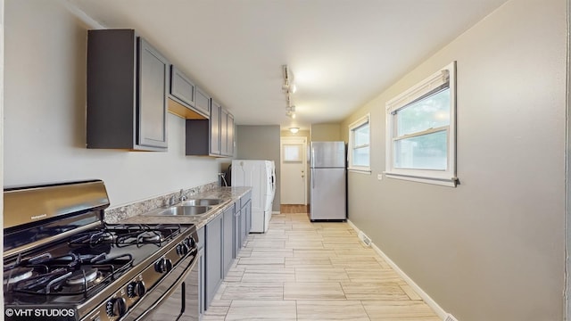1917 W 163rd St, Markham, IL 60428 - kitchen with stainless steel appliances, washer / dryer, gray cabinetry, light countertops, and track lighting