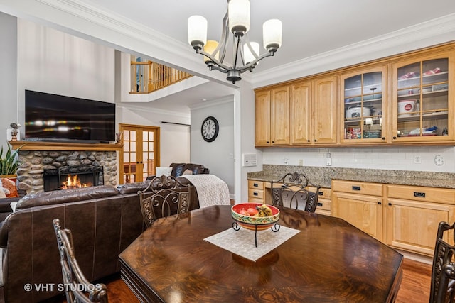436 Kelly Ln, Crystal Lake, IL 60012 - dining space featuring a chandelier, crown molding, wood finished floors, a stone fireplace, and french doors