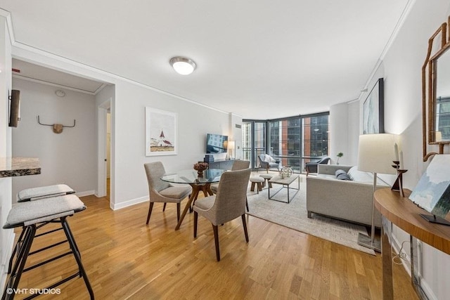 450 E Waterside Dr Unit 906, Chicago, IL 60601 - dining space featuring crown molding, light wood-style floors, and baseboards