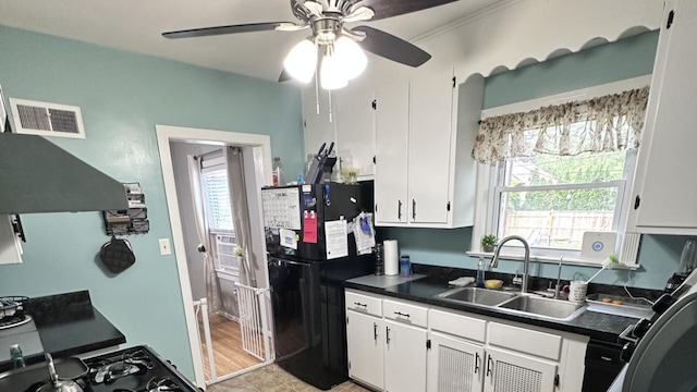 963 Oneida St, Joliet, IL 60435 - kitchen with freestanding refrigerator, dark countertops, ceiling fan, and white cabinets