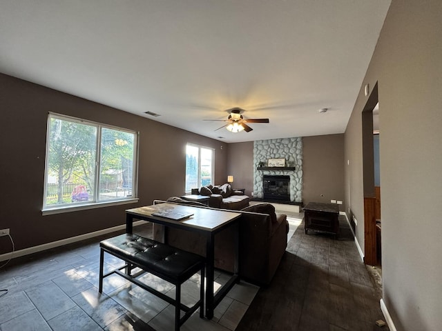 1419 Major Dr, Plainfield, IL 60586 - living room featuring a stone fireplace, ceiling fan, baseboards, and dark wood-style flooring