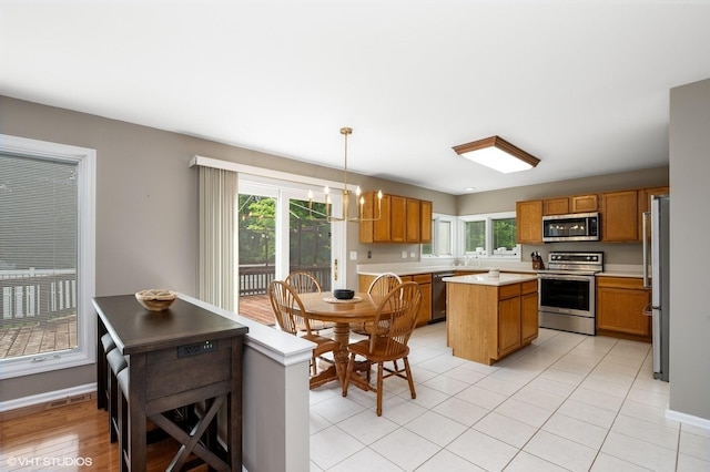 1370 Glacier Pkwy, Algonquin, IL 60102 - kitchen with stainless steel appliances, brown cabinetry, light countertops, and a center island