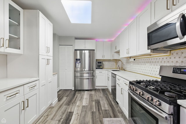 421 Pintail Ln, Deerfield, IL 60015 - kitchen featuring appliances with stainless steel finishes, wood finished floors, white cabinets, tasteful backsplash, and glass insert cabinets