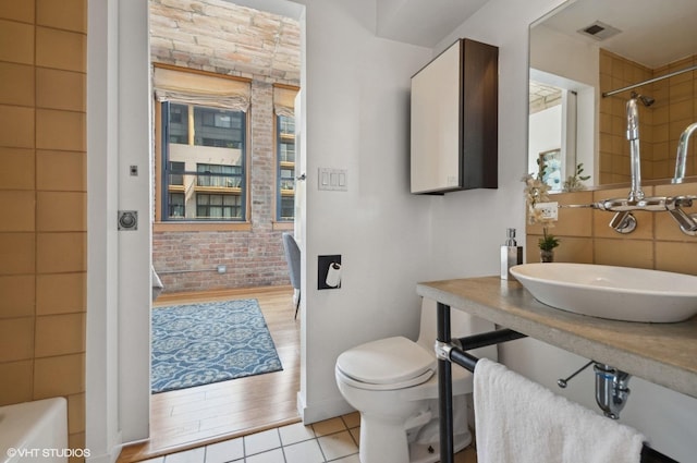 120 E Cullerton St Unit 402, Chicago, IL 60616 - bathroom featuring tile patterned floors and brick wall