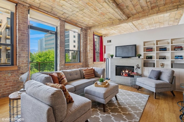 120 E Cullerton St Unit 402, Chicago, IL 60616 - living room with wood finished floors, brick ceiling, brick wall, and a warm lit fireplace