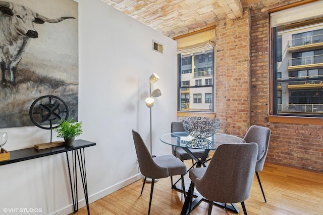 120 E Cullerton St Unit 402, Chicago, IL 60616 - dining room featuring brick ceiling, brick wall, and wood finished floors