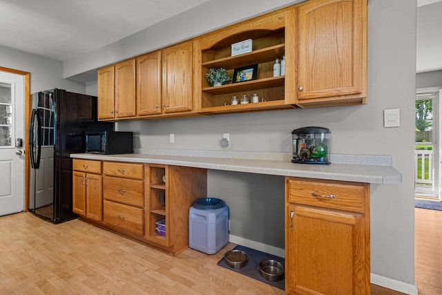 1716 Park Haven Dr, Champaign, IL 61820 - kitchen with black appliances, open shelves, light wood-type flooring, light countertops, and brown cabinets