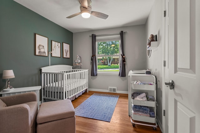 1716 Park Haven Dr, Champaign, IL 61820 - bedroom with wood finished floors, a nursery area, baseboards, and ceiling fan