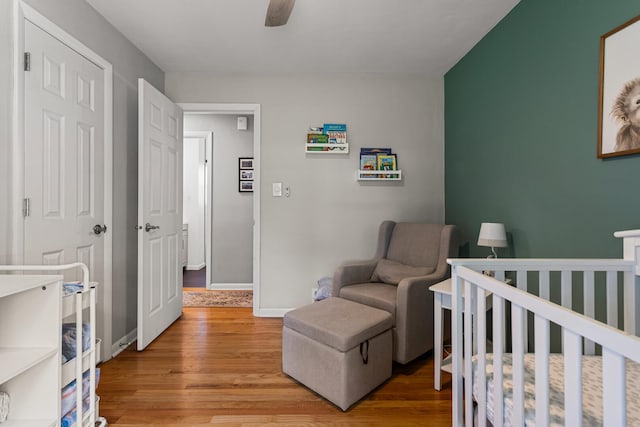 1716 Park Haven Dr, Champaign, IL 61820 - bedroom with light wood-type flooring, a nursery area, ceiling fan, and baseboards