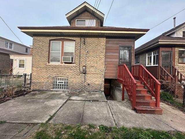 rear view of house featuring a patio, brick siding, and cooling unit
