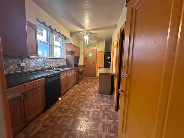 kitchen featuring dishwasher, decorative backsplash, dark countertops, a ceiling fan, and a sink