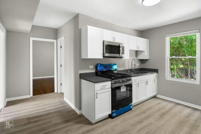 13739 Kildare Ave, Crestwood, IL 60418 - kitchen with stainless steel appliances, a sink, light wood-style flooring, baseboards, and white cabinetry