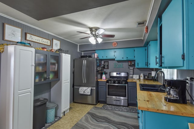 502 Short St, Cornell, IL 61319 - kitchen featuring appliances with stainless steel finishes, blue cabinetry, ornamental molding, wooden counters, and a ceiling fan
