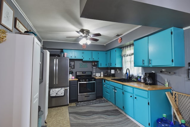 502 Short St, Cornell, IL 61319 - kitchen with appliances with stainless steel finishes, crown molding, ceiling fan, blue cabinets, and light countertops