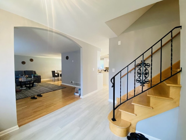 1106 Westfield Ln, Schaumburg, IL 60193 - stairs featuring arched walkways, wood finished floors, and baseboards