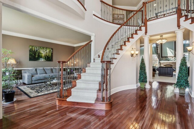 24 Wood Oaks Dr, South Barrington, IL 60010 - stairway with hardwood / wood-style floors, baseboards, a towering ceiling, crown molding, and ornate columns