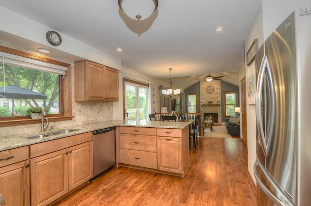 1344 Saddlebrook Rd, Bartlett, IL 60103 - kitchen featuring appliances with stainless steel finishes, a peninsula, wood finished floors, light stone counters, and backsplash
