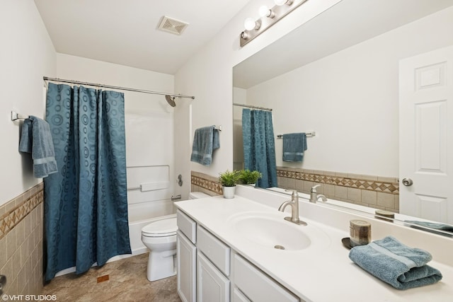 11 Litchfield Ct, Lake In The Hills, IL 60156 - bathroom with vanity, shower / bath combination with curtain, tile walls, and a wainscoted wall