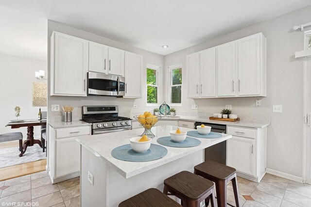11 Litchfield Ct, Lake In The Hills, IL 60156 - kitchen featuring appliances with stainless steel finishes, light countertops, white cabinetry, and a kitchen breakfast bar