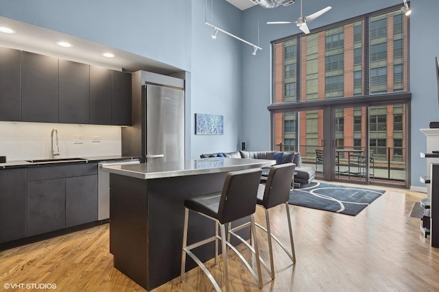 616 W Fulton St Unit 703, Chicago, IL 60661 - kitchen featuring a high ceiling, light wood-style floors, a breakfast bar, open floor plan, and dishwasher