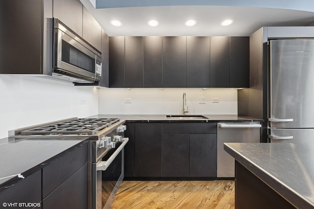 616 W Fulton St Unit 703, Chicago, IL 60661 - kitchen featuring appliances with stainless steel finishes, light wood-style flooring, modern cabinets, recessed lighting, and dark cabinetry