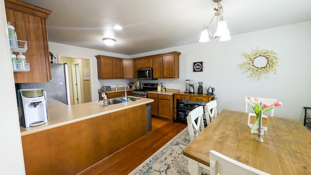 3908 Summer Sage Ct, Champaign, IL 61822 - kitchen with stainless steel appliances, dark wood-style floors, a chandelier, a peninsula, and brown cabinetry