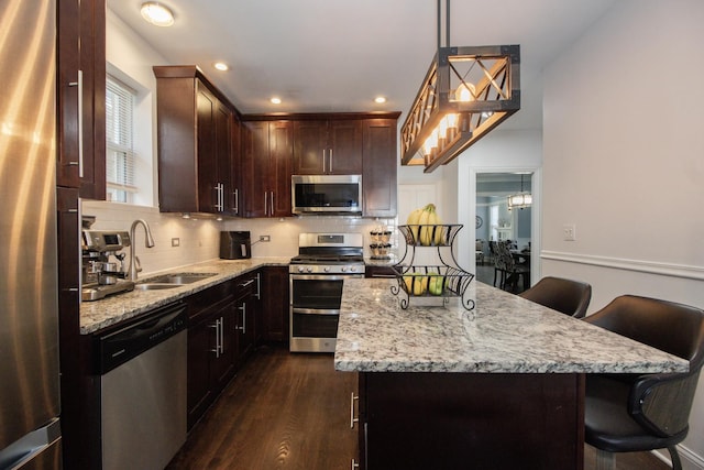 5236 W Nelson St, Chicago, IL 60641 - kitchen with stainless steel appliances, light stone countertops, a kitchen island, a breakfast bar area, and recessed lighting