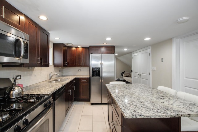 5236 W Nelson St, Chicago, IL 60641 - kitchen featuring appliances with stainless steel finishes, a center island, light stone countertops, tasteful backsplash, and recessed lighting
