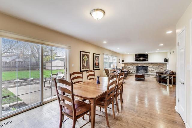 613 Michelline Ln, Northbrook, IL 60062 - dining room featuring a fireplace, plenty of natural light, light wood-type flooring, and recessed lighting