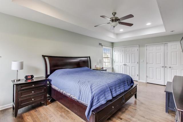 613 Michelline Ln, Northbrook, IL 60062 - bedroom with a raised ceiling, multiple closets, wood finished floors, baseboards, and recessed lighting