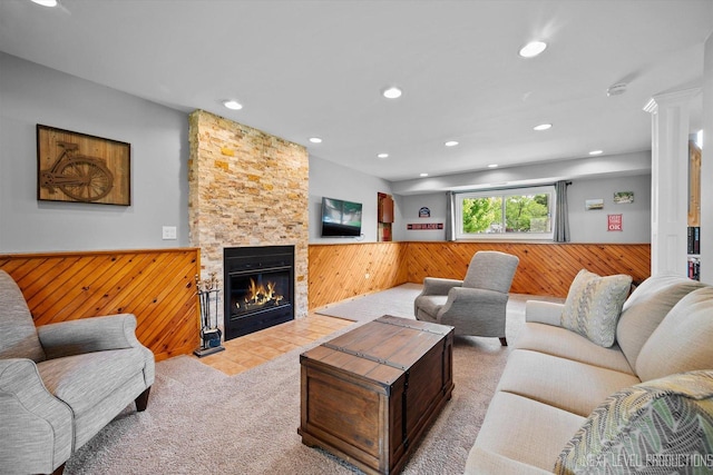 1035 Warwick Cir N, Hoffman Estates, IL 60169 - carpeted living room with wood walls, wainscoting, recessed lighting, decorative columns, and a stone fireplace