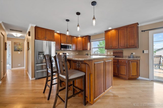 1035 Warwick Cir N, Hoffman Estates, IL 60169 - kitchen featuring appliances with stainless steel finishes, crown molding, light wood-type flooring, brown cabinetry, and decorative light fixtures