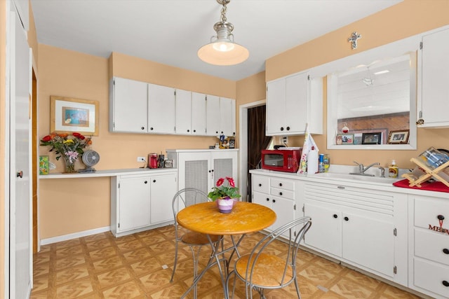 415 Fremont St, Lemont, IL 60439 - kitchen featuring light countertops, white cabinets, white microwave, light flooring, and a sink