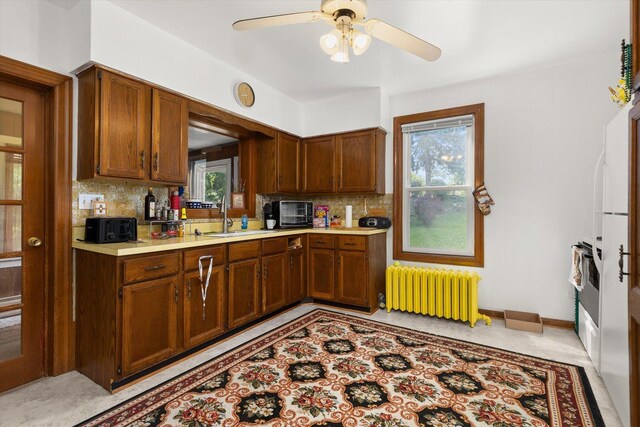 415 Fremont St, Lemont, IL 60439 - kitchen with radiator heating unit, a sink, tasteful backsplash, a ceiling fan, and light countertops