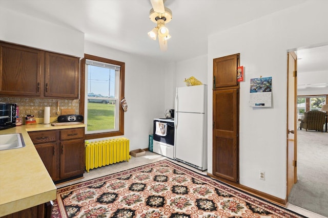415 Fremont St, Lemont, IL 60439 - kitchen featuring radiator heating unit, white appliances, light countertops, decorative backsplash, and baseboards