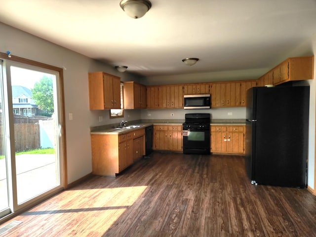 609 Flanagan Dr, Minooka, IL 60447 - kitchen featuring black appliances, dark wood-style floors, brown cabinets, and light countertops