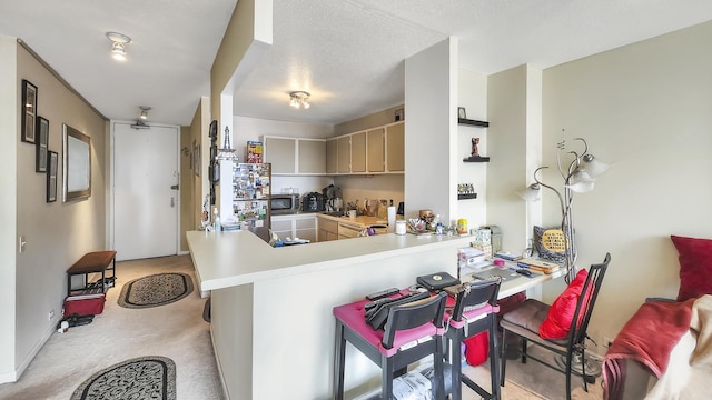 405 N Wabash Ave Unit 2809, Chicago, IL 60611 - kitchen with light colored carpet, stainless steel microwave, light countertops, a peninsula, and a breakfast bar area