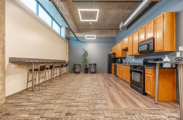 210 S Desplaines St Unit 1410, Chicago, IL 60661 - kitchen with black appliances, dark countertops, and light wood-style flooring