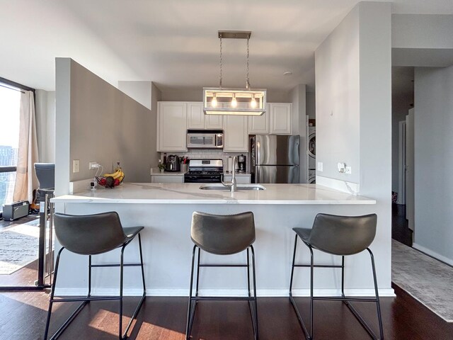 210 S Desplaines St Unit 1410, Chicago, IL 60661 - kitchen with appliances with stainless steel finishes, a peninsula, white cabinets, and a breakfast bar