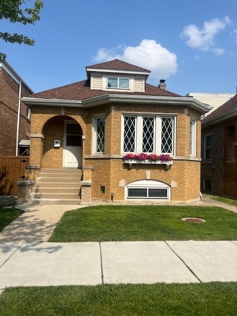 6111 S Menard Ave, Chicago, IL 60638 - bungalow-style home with a front yard, brick siding, and a shingled roof