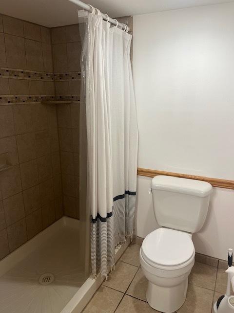 6111 S Menard Ave, Chicago, IL 60638 - bathroom with tile patterned flooring, toilet, a stall shower, and baseboards