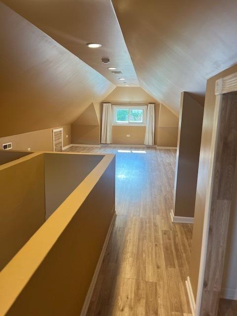 6111 S Menard Ave, Chicago, IL 60638 - additional living space featuring light wood finished floors, lofted ceiling, and baseboards